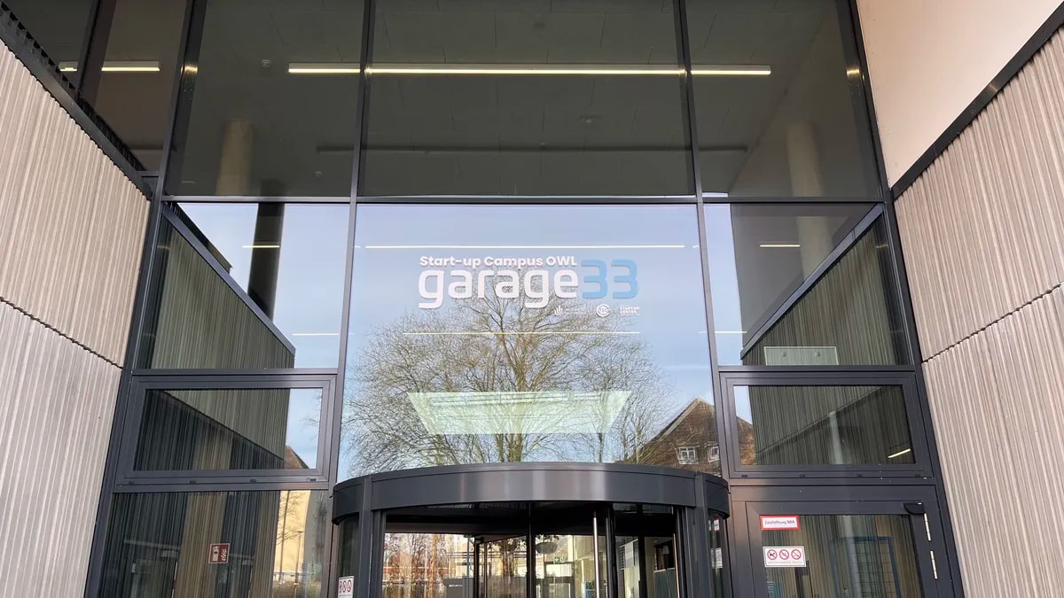 Eingang der garage33 mit dem Schriftzug Start-up Campus OWL über der Drehtür