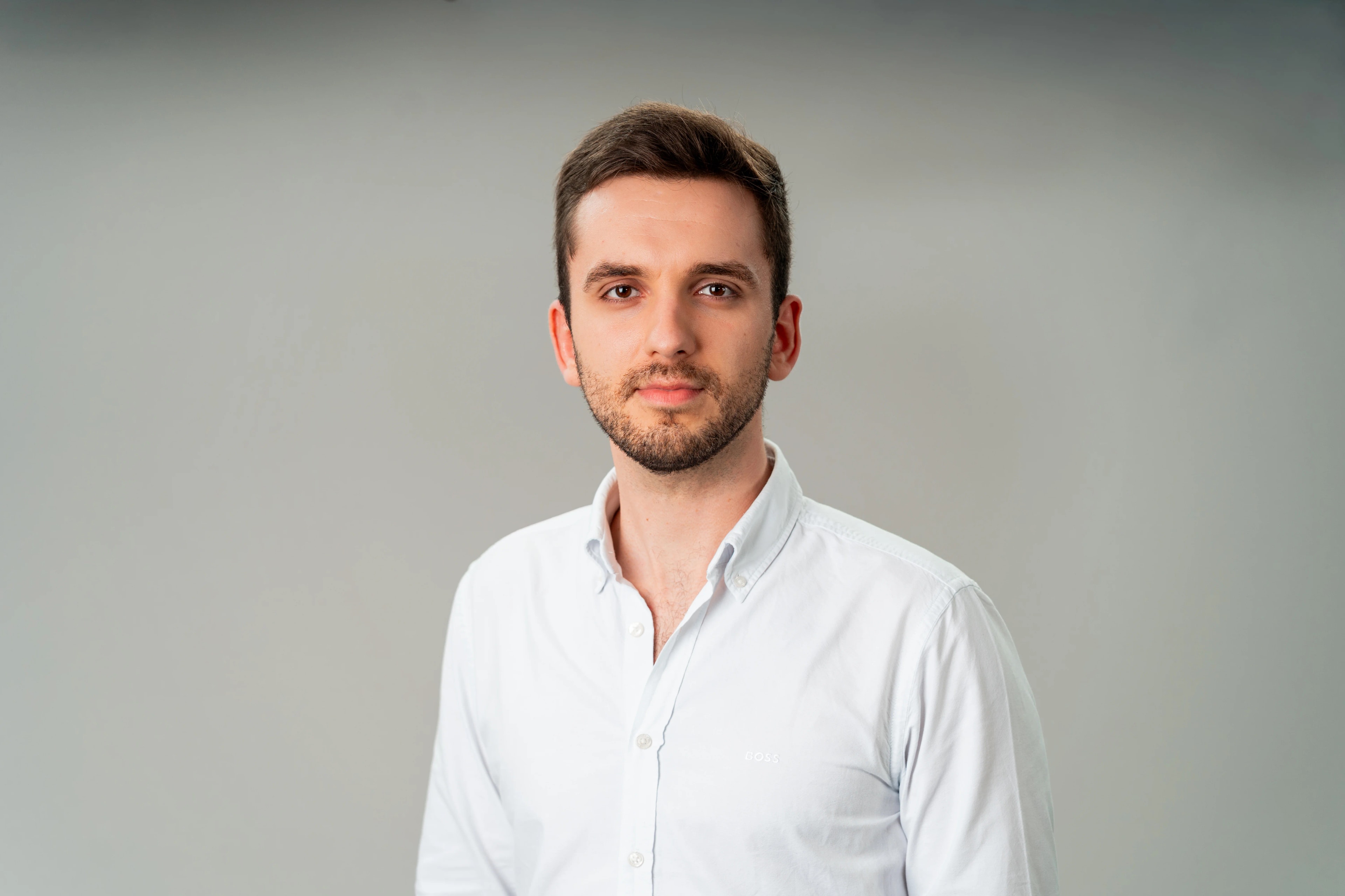 Konstantin Anklam im weißen Hemd, Studioaufnahme vor hellgrauem Grund